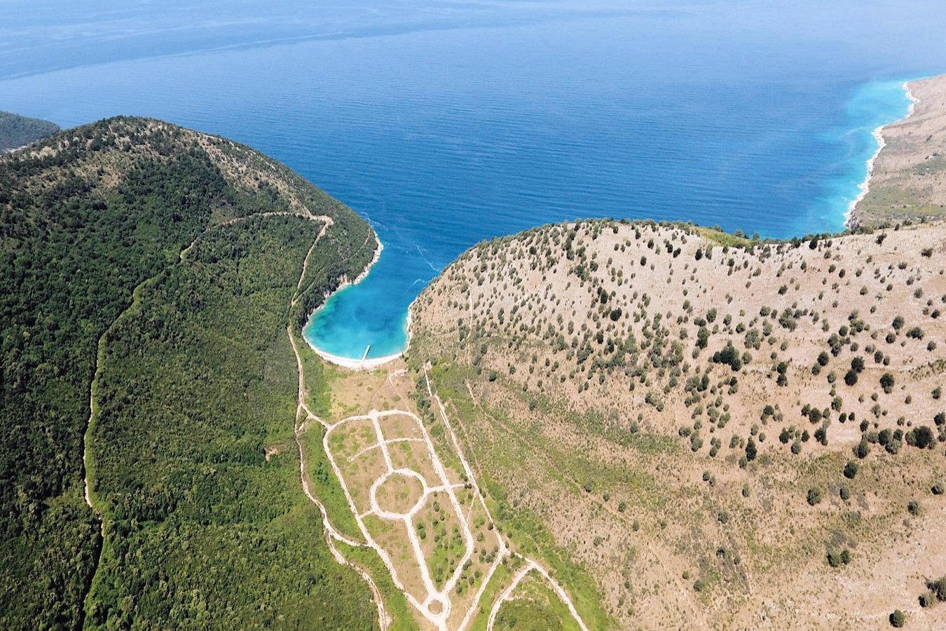 Untouched Kakome Beach, surrounded by lush hills and blue waters